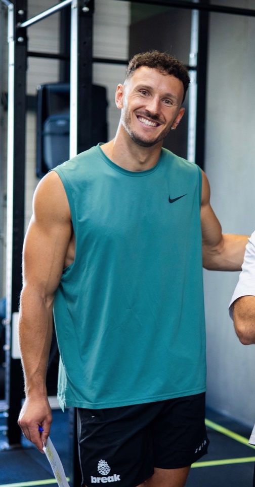 Flo, responsable sportif, souriant dans la salle.