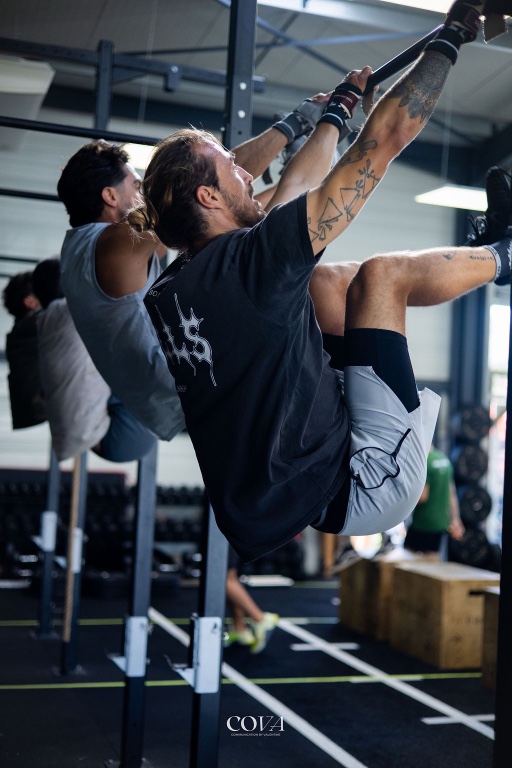 Un adhérent enchaîne des montées de pointes à la barre pendant un WOD.
